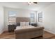 Cozy bedroom featuring a tufted headboard, hardwood floors, and ample natural light from the windows at 15315 Golden Beam Pl, Bradenton, FL 34211