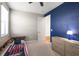 Well-lit bedroom with a striking blue accent wall, featuring a bed with built-in shelving at 15315 Golden Beam Pl, Bradenton, FL 34211