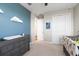 Charming Bedroom with blue accent wall and wooden changing table, adjacent to a carpeted room at 15315 Golden Beam Pl, Bradenton, FL 34211