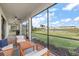 Relaxing screened patio with comfortable seating, overlooking a large backyard and scenic pond at 15315 Golden Beam Pl, Bradenton, FL 34211