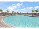 Inviting community pool offers a serene spot for relaxation with ample lounge seating and palm trees at 15315 Golden Beam Pl, Bradenton, FL 34211