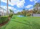 Expansive backyard featuring lush green grass and tranquil pond views, providing a serene outdoor space at 1545 Deerbourne Dr, Wesley Chapel, FL 33543