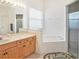 Bright bathroom with double vanity, large tub, and separate glass shower at 1545 Deerbourne Dr, Wesley Chapel, FL 33543