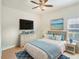 Bright bedroom with a beach painting, comfortable bed, ceiling fan, and stylish decor at 1545 Deerbourne Dr, Wesley Chapel, FL 33543