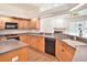 Open kitchen with wood cabinets, modern appliances, and a view to the living area at 1545 Deerbourne Dr, Wesley Chapel, FL 33543