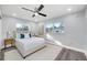 This bedroom features hardwood floors, neutral paint and carpet, a ceiling fan and plenty of natural light at 1811 Forest Dr, Oldsmar, FL 34677