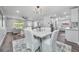Open concept dining room with modern lighting, hardwood floors, and views to the kitchen and living area at 1811 Forest Dr, Oldsmar, FL 34677