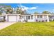 Charming single-story home featuring a well-manicured lawn and a freshly painted gray exterior at 1811 Forest Dr, Oldsmar, FL 34677
