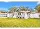Angle view of a single-story home with lush green lawn, showcasing its freshly painted gray exterior at 1811 Forest Dr, Oldsmar, FL 34677