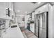 Bright kitchen features white cabinetry, stainless steel appliances, and a stylish gray backsplash at 1811 Forest Dr, Oldsmar, FL 34677