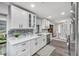 Bright kitchen features white cabinetry, stainless steel appliances, and a stylish gray backsplash at 1811 Forest Dr, Oldsmar, FL 34677