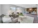 Bright living room with large windows, fireplace, and neutral-toned furniture at 1811 Forest Dr, Oldsmar, FL 34677