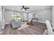 Bright living room featuring hardwood floors, a modern ceiling fan, and stylish decor at 1811 Forest Dr, Oldsmar, FL 34677