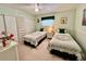 Bedroom with two twin beds, neutral carpet, and floral accents at 205 Seagull N Dr, Tarpon Springs, FL 34689