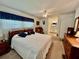 Bedroom featuring a wooden bed frame, ceiling fan, adjacent bathroom, and carpet flooring at 205 Seagull N Dr, Tarpon Springs, FL 34689