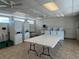 Bright laundry room with multiple washers, dryers, folding tables, and clean tiled floors at 205 Seagull N Dr, Tarpon Springs, FL 34689