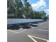 Parking lot enclosed by a long white fence and large shady trees in the background at 205 Seagull N Dr, Tarpon Springs, FL 34689