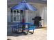 Blue picnic table and charcoal grill outside the community clubhouse with a blue umbrella at 205 Seagull N Dr, Tarpon Springs, FL 34689