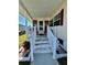 A welcoming front porch with white railings and steps leads to the entrance of this charming home at 205 Seagull N Dr, Tarpon Springs, FL 34689