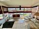 Bright sunroom featuring tiled floors, plenty of windows, and comfortable wicker furniture at 205 Seagull N Dr, Tarpon Springs, FL 34689