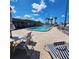 Community pool surrounded by tables, chairs, and lounge chairs with a clubhouse in the background at 205 Seagull N Dr, Tarpon Springs, FL 34689