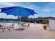 Inviting poolside patio with tables, chairs, and a large blue umbrella at 315 Caloosa Palms Ct, Sun City Center, FL 33573