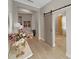 Charming entryway featuring light, neutral walls, wood-look tile floors, and stylish barn door at 4375 Barletta Ct, Wesley Chapel, FL 33543