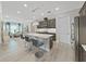 Open-concept kitchen featuring an island with seating, stainless steel appliances and wood-look tile floors at 4375 Barletta Ct, Wesley Chapel, FL 33543
