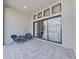 An outdoor patio has sliding glass doors and is furnished with a small table and chairs at 4375 Barletta Ct, Wesley Chapel, FL 33543