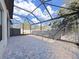 Screened-in patio with brick pavers and view of the backyard at 4375 Barletta Ct, Wesley Chapel, FL 33543