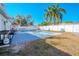 Backyard with a pool, palm trees, and outdoor seating against a white fence at 6961 Dalkeith N Ave, St Petersburg, FL 33709