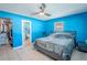 Bright blue bedroom with closet, ensuite bathroom, and a grey bed with matching nightstand at 6961 Dalkeith N Ave, St Petersburg, FL 33709
