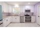 Well-lit kitchen with white cabinets, stainless steel appliances, and granite countertops at 6961 Dalkeith N Ave, St Petersburg, FL 33709