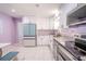 Modern kitchen with white cabinets, stainless steel appliances, and granite countertops at 6961 Dalkeith N Ave, St Petersburg, FL 33709