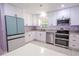 Bright kitchen features white cabinets, stainless steel appliances, and granite countertops at 6961 Dalkeith N Ave, St Petersburg, FL 33709