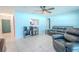 Light blue living room with grey tile, grey furniture, and view into the kitchen at 6961 Dalkeith N Ave, St Petersburg, FL 33709