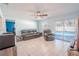 Cozy living room with tile floors, ceiling fan, comfortable seating, and slider to the pool at 6961 Dalkeith N Ave, St Petersburg, FL 33709
