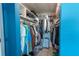 Bright blue walk-in closet with shelving, clothes hanging, and storage on the floor at 6961 Dalkeith N Ave, St Petersburg, FL 33709