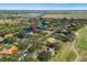 Aerial view of a community featuring single-Gathering homes, lush greenery, and a serene lake at 7185 N Serenoa Dr, Sarasota, FL 34241