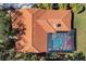 Aerial view of a home with a terracotta roof, screened-in pool, and lush landscaping at 7185 N Serenoa Dr, Sarasota, FL 34241