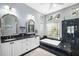 Elegant bathroom with a double vanity, soaking tub, glass block window, and a separate glass-enclosed shower at 7185 N Serenoa Dr, Sarasota, FL 34241