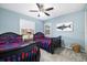 Charming bedroom featuring twin beds, ceiling fan, window with shutters, and a colorful shark painting at 7185 N Serenoa Dr, Sarasota, FL 34241