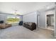 Comfortable bonus room featuring a bay window with seating, multiple couches, and access to the bathroom and hall at 7185 N Serenoa Dr, Sarasota, FL 34241