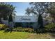 A beautifully landscaped community entrance featuring a stone sign surrounded by flowers and greenery at 7185 N Serenoa Dr, Sarasota, FL 34241
