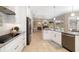 Modern kitchen with stainless steel appliances, white cabinets, and access to the outdoor living area and pool at 7185 N Serenoa Dr, Sarasota, FL 34241