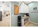 Clean laundry room featuring built-in shelving, granite countertops and modern water dispenser at 7185 N Serenoa Dr, Sarasota, FL 34241