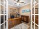 Inviting home office with natural wood desk, a tropical theme and shuttered windows at 7185 N Serenoa Dr, Sarasota, FL 34241
