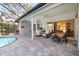 Outdoor patio featuring a dining table and chairs, wicker seating, and a view of the living room through sliding glass doors at 7185 N Serenoa Dr, Sarasota, FL 34241