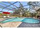Inviting screened-in pool and spa with brick pavers, lounge chairs, and beautiful views of the surrounding landscape at 7185 N Serenoa Dr, Sarasota, FL 34241