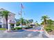 The entrance to Bay Island features flags, lush greenery, and a secure gatehouse for residents' privacy at 7420 Bay Island S Dr # 281, South Pasadena, FL 33707